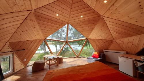 una grande camera con un grande soffitto in legno in una casa sull'albero di Domaine du Balbuzard a Condat-en-Combraille