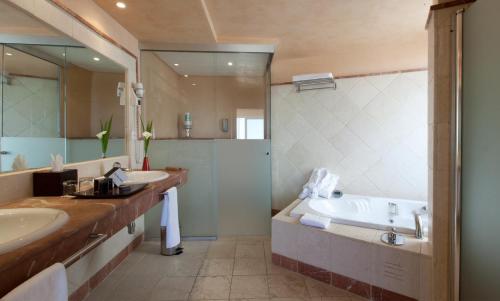 a bathroom with two sinks and a tub and a shower at Senator Banus in Estepona