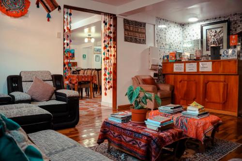 Intitambo Hotel في أولانتايتامبو: غرفة معيشة مع أريكة وطاولة مع كتب
