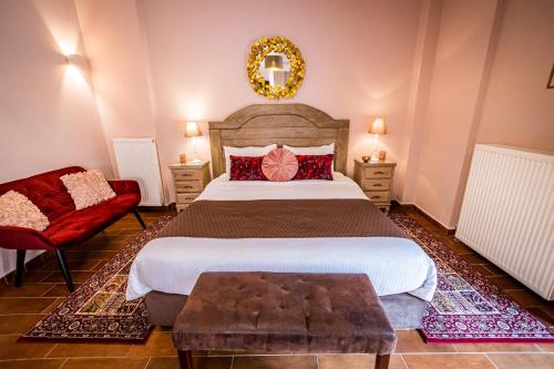 a bedroom with a large bed and a red chair at MARON in Kalavrita