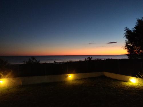 a sunset from the back yard of a house with lights at Katakolo 180ο Sea View house near Ancient Olympia in Katakolon