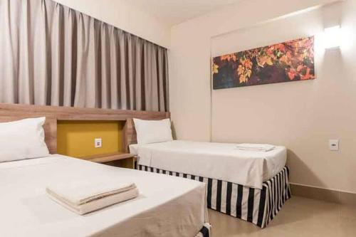 a hotel room with two beds and a painting on the wall at Enjoy Solar das Águas Park Resort in Olímpia