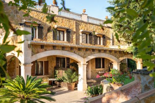 an old stone building with plants in front of it at Hotel Son Molí Country House in Playa de Palma
