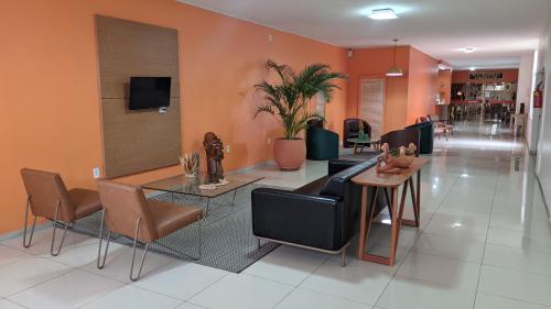 eine Lobby mit einem Tisch und Stühlen und einer unbeabsichtigten in der Unterkunft Hotel do Grande Rio in Petrolina