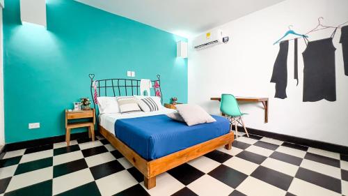 een slaapkamer met een bed en een blauwe muur bij Puerta Aqua by La Puerta Hostels in Santa Marta