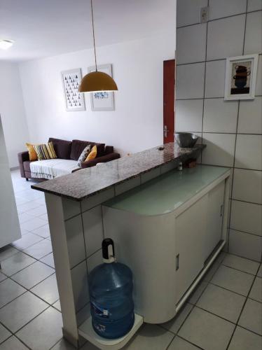 una cocina con una barra con una jarra azul debajo en Apartamento com piscina a uma quadra da praia de jatiuca, en Maceió