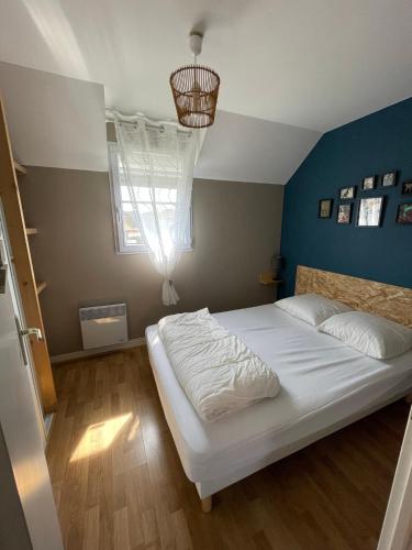 - une chambre avec un lit blanc et un mur bleu dans l'établissement Location maison vacances 4 pers proche plage chez Lili Berck, à Berck-sur-Mer