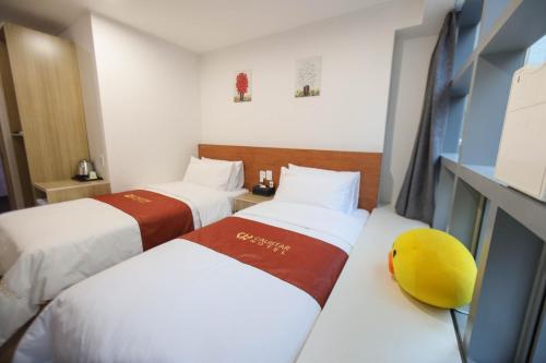 a hotel room with two beds and a tv at Calistar Hotel in Seoul
