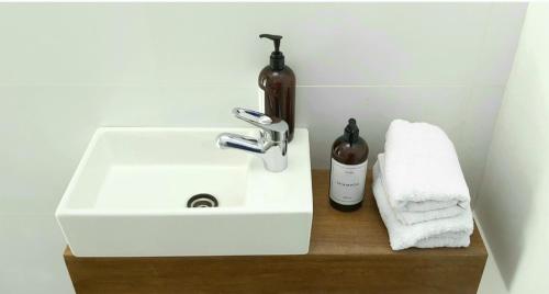 lavabo con dispensador de jabón y botella en Andrea Houses, en Chacras de Coria