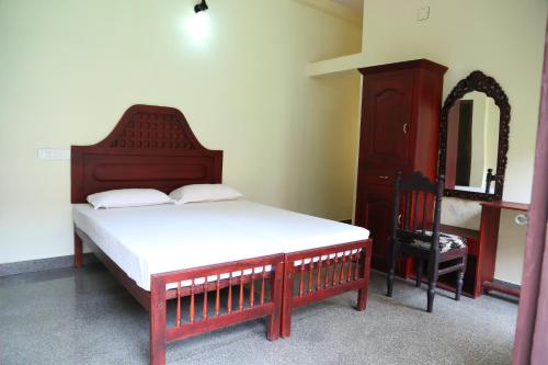 1 dormitorio con cama, tocador y espejo en Alapatt Homestay, en Alleppey