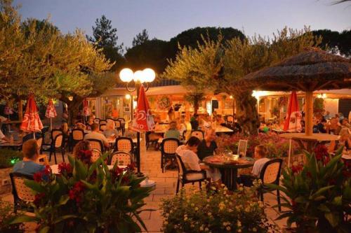 grupa ludzi siedząca przy stołach w restauracji w obiekcie Mobile home 5-pers Camping Leï Suves-Côtes d'Azur-including airco w mieście Roquebrune-sur Argens