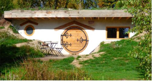 a house with a large door and a table outside at Domaine du Balbuzard in Condat-en-Combraille
