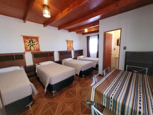 a hotel room with three beds and a fireplace at Lalck Cketi Hospedaje y Turismo in San Pedro de Atacama