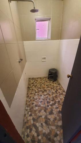 a small room with a tiled floor and a window at Posada Doña Mari Aeropuerto in Mexico City