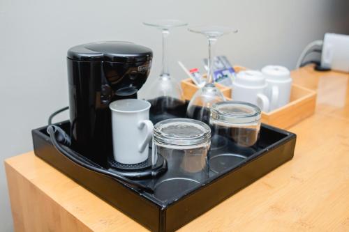 a tray with cups and a coffee maker on a counter at Sonesta Hotel Osorno in Osorno