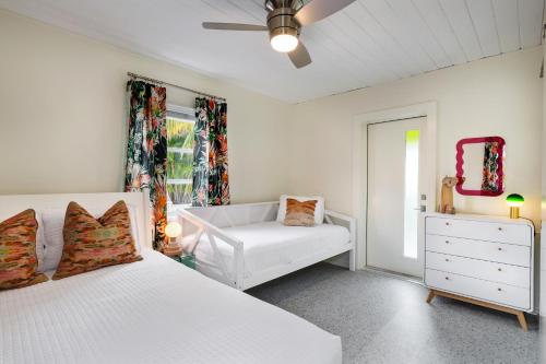 a bedroom with two beds and a couch and a window at Sunset Inn and Cottages in St. Pete Beach