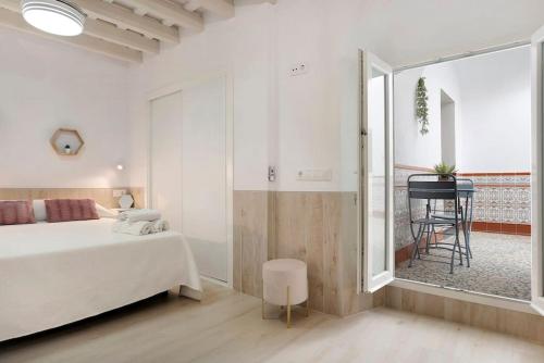 Schlafzimmer mit einem Bett, einem Tisch und einem Fenster in der Unterkunft Apartamento Cobarrubias in Vejer de la Frontera