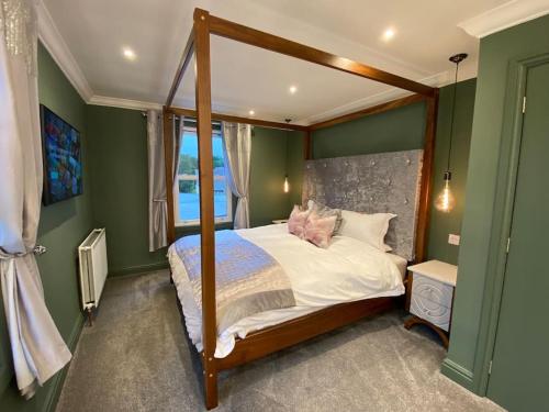 a bedroom with a canopy bed and a window at The Retreat at La Sagesse in Windermere