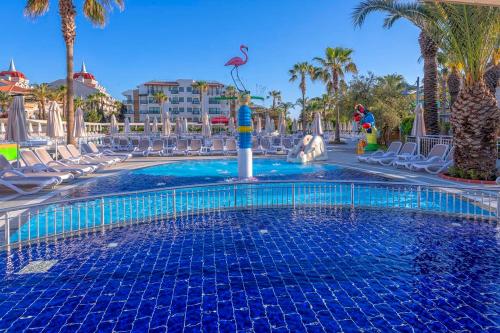 einen Pool in einem Resort mit Stühlen und Palmen in der Unterkunft Belek Beach Resort Hotel in Belek