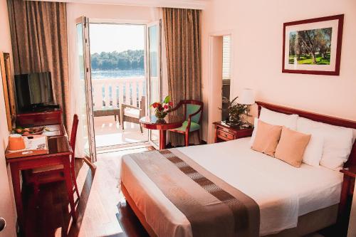 a hotel room with a bed and a balcony at Hotel Bozica Dubrovnik Islands in Suđurađ