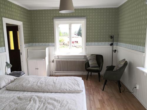 a bedroom with a bed and a window and a chair at Gula huset, Lakene Ostgård in Lakene