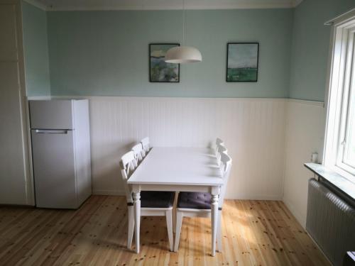 a kitchen with a table and chairs and a refrigerator at Gula huset, Lakene Ostgård in Lakene