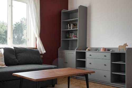 a living room with a couch and a table at Gula huset, Lakene Ostgård in Lakene