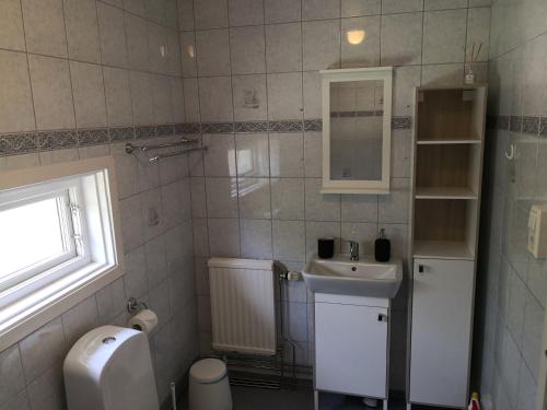 a white bathroom with a sink and a mirror at Gula huset, Lakene Ostgård in Lakene