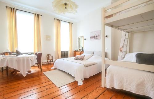 a bedroom with two beds and a table and a desk at -- La main à la pâte -- in Boulogne-sur-Mer