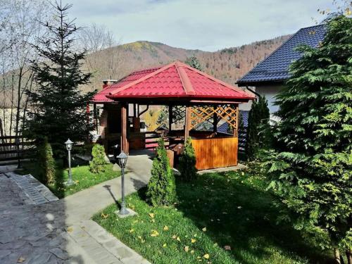 a gazebo with a red roof in a yard at Old Mark's House Sinaia in Sinaia