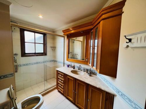 bagno con lavandino e doccia di MRG- Colonial 2D - 200 mts da Rua Torta a Gramado