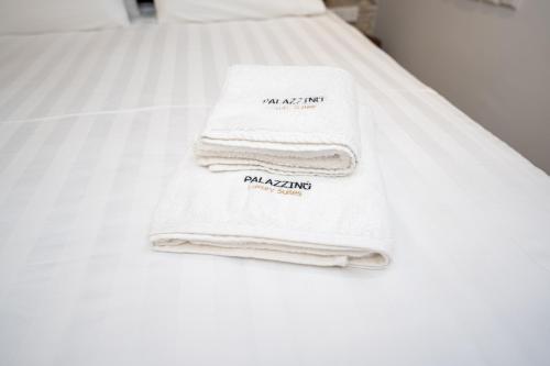 a pile of towels sitting on a bed at Palazzino Luxury Suites in Lofou
