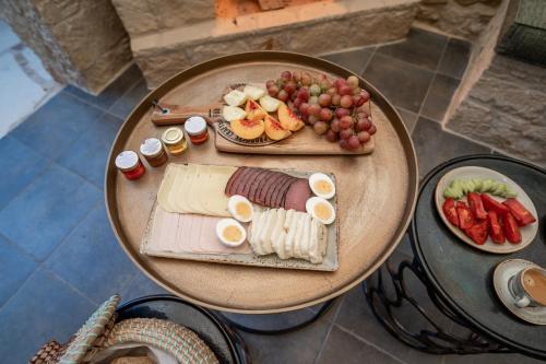 a table with a plate of food and fruit on it at Palazzino Luxury Suites in Lofou