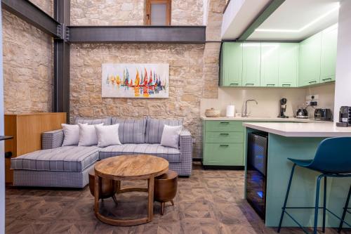 a kitchen and a living room with a couch and a table at Palazzino Luxury Suites in Lofou