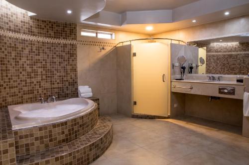 uma casa de banho com uma banheira grande e um lavatório em Hotel Santorian em Hermosillo