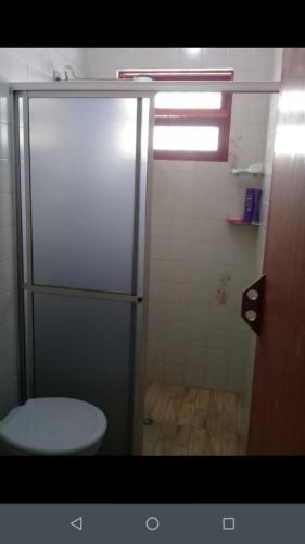a bathroom with a toilet and a shower stall at Casa com piscina em Mongaguá in Mongaguá