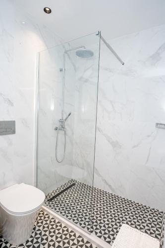 a bathroom with a glass shower with a toilet at Palazzino Luxury Suites in Lofou