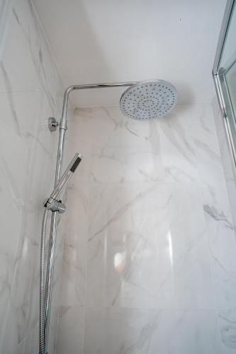 a shower with a glass door and a shower head at Palazzino Luxury Suites in Lofou