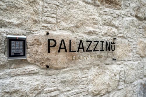 a sign on the side of a stone wall at Palazzino Luxury Suites in Lofou