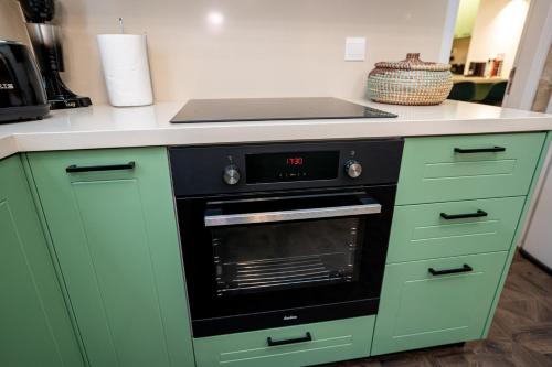 a kitchen with green cabinets and an oven at Palazzino Luxury Suites in Lofou