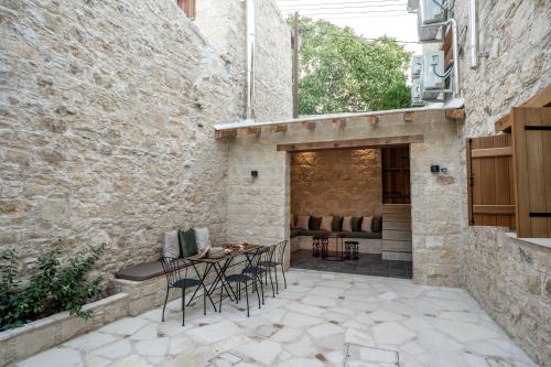 a patio with a table and chairs in a building at Palazzino Luxury Suites in Lofou