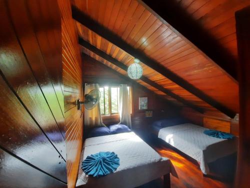 an attic bedroom with two beds in a room at Beachfront with mountain view in Puerto Jiménez
