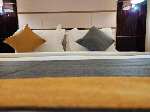 a bedroom with a bed with pillows at Rasis Serviced Apartments in Jeddah