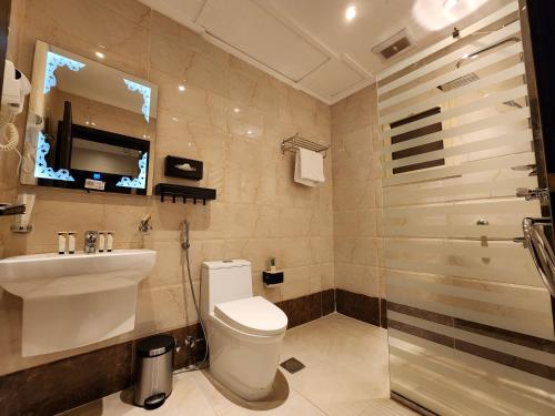 y baño con aseo, lavabo y ducha. en Rasis Furnished Apartments en Yeda