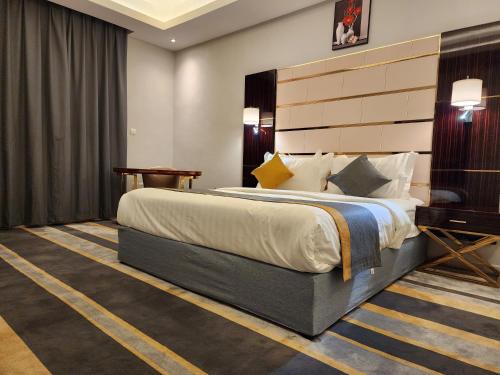 a hotel room with a large bed and a desk at Rasis Furnished Apartments in Jeddah