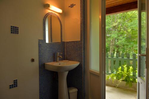 baño con lavabo, espejo y ventana en Gîte de Montagne Salle de Fête Thorenc, en Andon