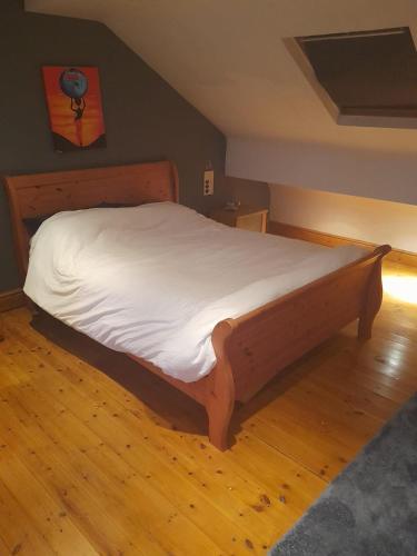 a large bed in a bedroom with a wooden floor at Alwyn House in Liverpool