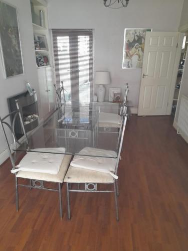 a glass table and two chairs in a room at Alwyn House in Liverpool