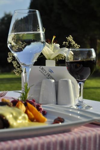 two glasses of wine and a plate of food at Orty Airport Hotel in Izmir
