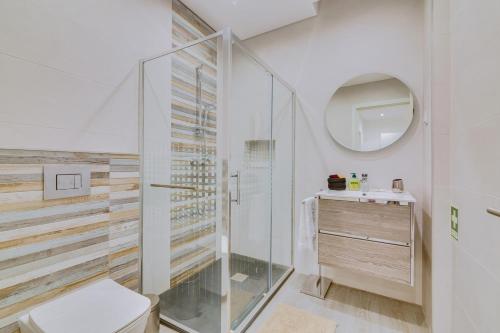 a bathroom with a glass shower and a toilet at Marina Star Guesthouse in Faro